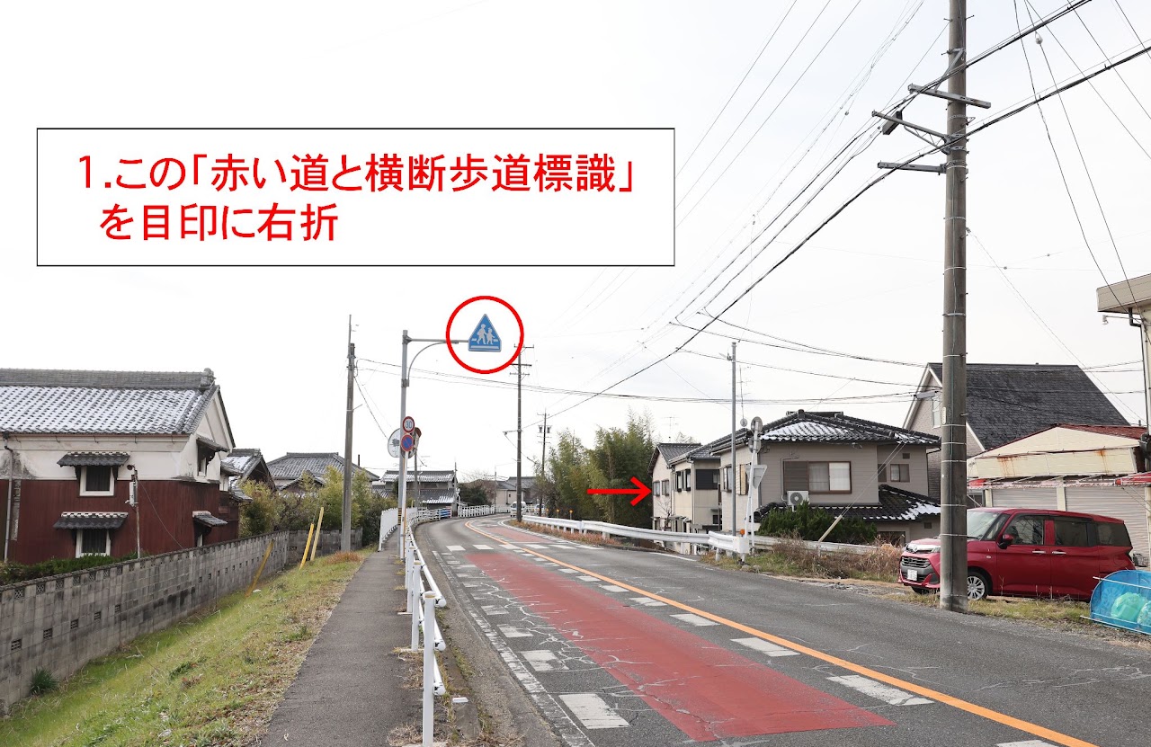 「赤い道と横断歩道標識」を目印に右折するT字路
